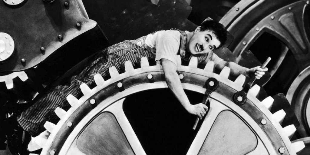 Charlie Chaplin intins pe o roata uriasa in Timpurile Moderne